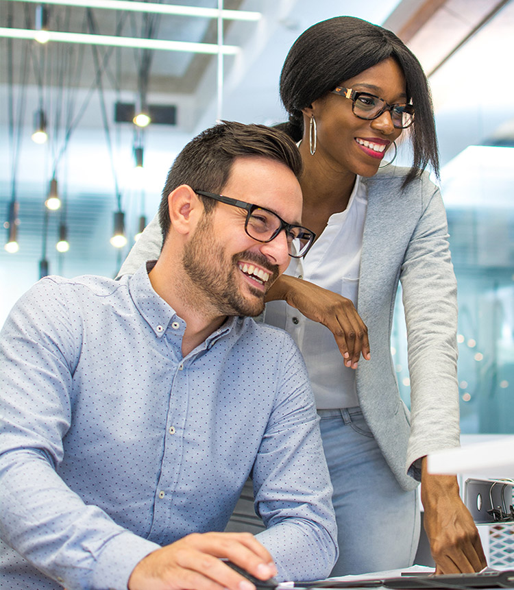 Employees collaborating at a computer