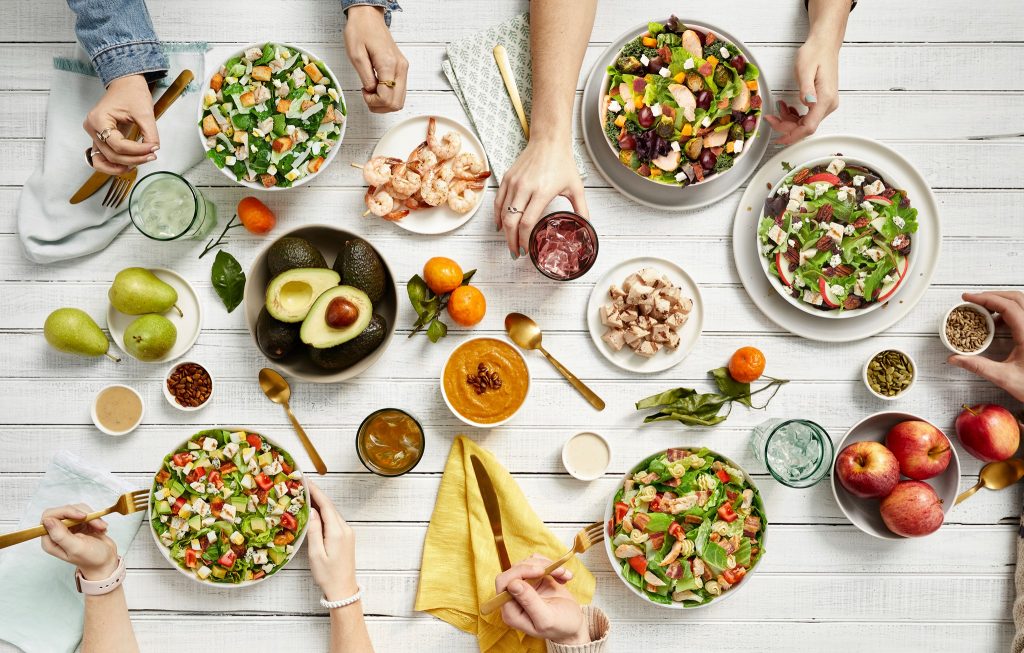 Table setting of people eating salads