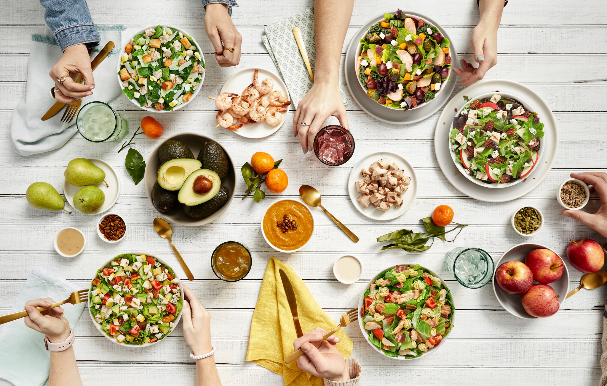 Table setting of people eating salads