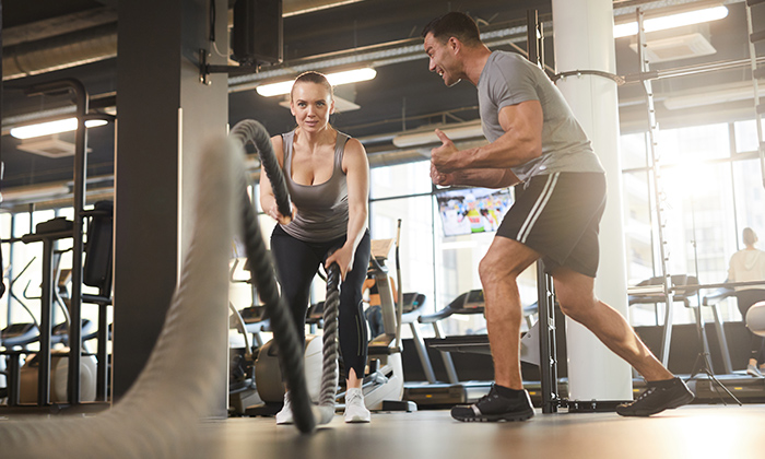 Woman working out in a gym with a trainer