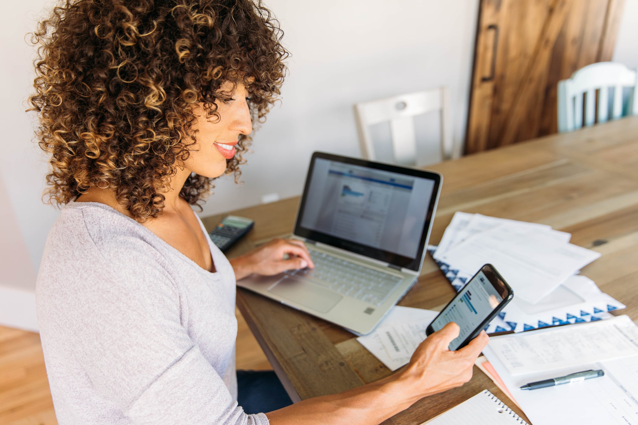 Women looking at financial graphs on her phone and computer