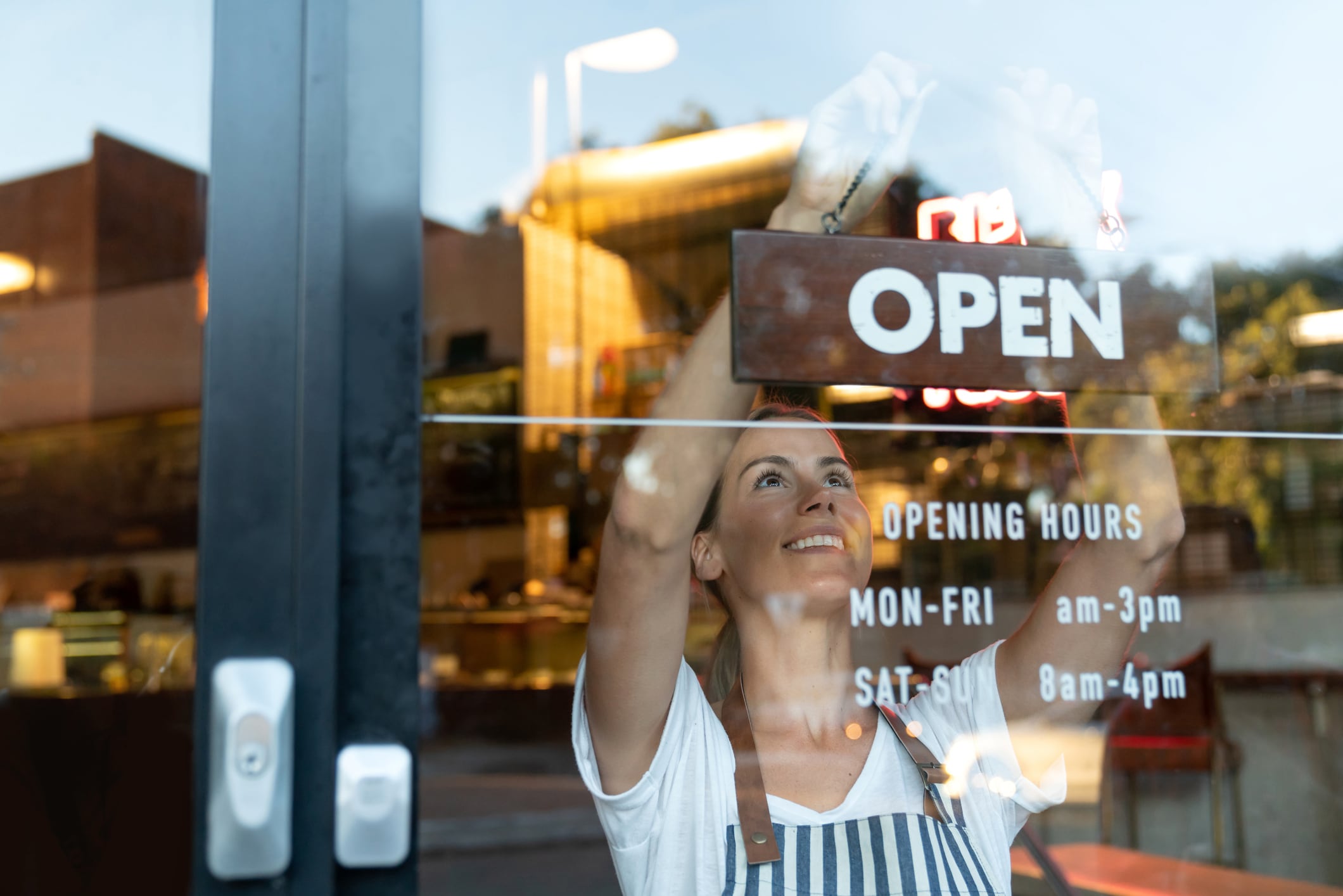 Women handing Open sign in window